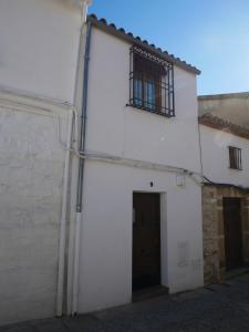 a white building with a door and a window at La Casilla: casa con piscina en centro histórico in Úbeda