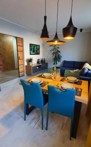 a dining room with a table and blue chairs at Apartament LuxLoft in Piechowice
