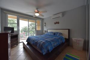 a bedroom with a bed and a ceiling fan at Seashore Condo in Rincon