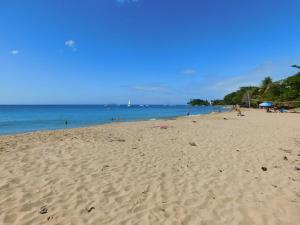 a sandy beach with people on the water at Seashore Condo in Rincon