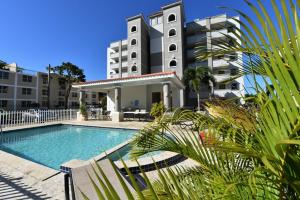 a swimming pool in front of a tall building at Seashore Condo in Rincon