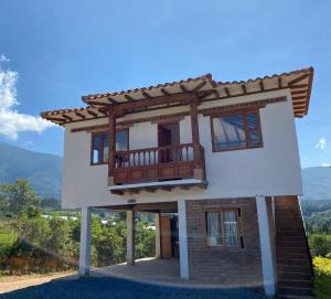 una casa con balcón en la parte superior en Caba-glamping La Fortuna de Luna en Villa de Leyva