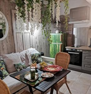 una sala de estar con una mesa con comida. en SIANDAKI NID D AMOUR AVEC JACUZZI, en La Motte