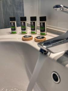 a bathroom sink with three bottles of hair products on it at "Olympia" Apartment of Levidi Arcadian Apartments in Levidi