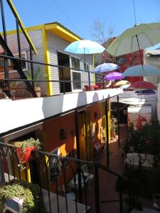 a building with umbrellas and tables and chairs at Andiamo Guest House in Buenos Aires