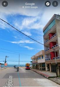 un edificio sul lato di una strada accanto alla spiaggia di APARTAMENTO PIUMA a Piúma