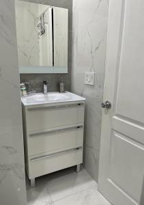 a white bathroom with a sink and a mirror at Casa Miami 1 in Miami