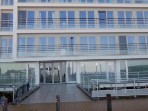 a large white building with a large balcony at Gelijkvloers zeezicht appartement Sterckx in Blankenberge