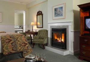 une chambre d'hôtel avec un lit et une cheminée dans l'établissement Lord Camden Inn, à Camden