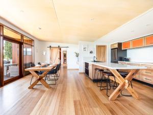 a kitchen and dining room with wooden tables and chairs at Little Oyster Bayview in Kettering