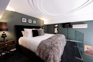 a bedroom with a large bed with a furry blanket at Hotel D'urville Blenheim in Blenheim