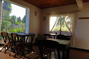 AONIKENK HOSTEL في إل كالافاتي: غرفة طعام مع طاولتين ونافذة