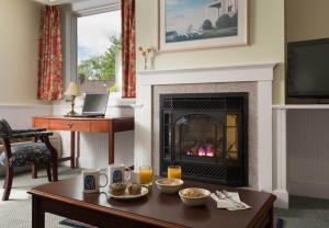 a living room with a fireplace with food on a table at Lord Camden Inn in Camden