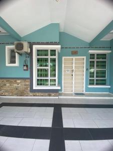 a room with blue walls and windows and a tile floor at illiy's homestay in Tangga Batu