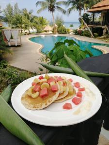 a plate of food on a table next to a pool at RED PEARL BEACH RESORT in Chaloklum