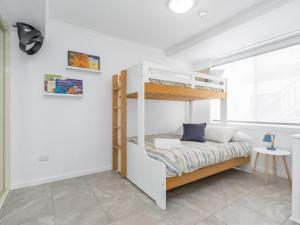 a bedroom with a bunk bed and a window at Nesuto Apartments Unit 509 in The Entrance