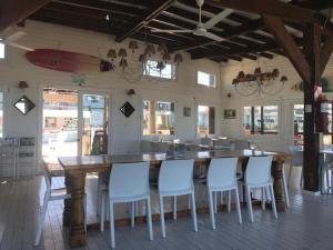 una cocina con una gran mesa de madera y sillas blancas. en Linda Bay spa playa Unidad 603 Mar de Las Pampas, en Mar de las Pampas