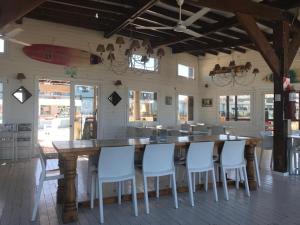 una cocina con una gran mesa de madera y sillas blancas. en Linda Bay Apart Unidad 603 Mar de Las Pampas en Mar de las Pampas