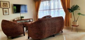 two wicker chairs in a living room with a television at Finca Bellavista Pereira in Pereira