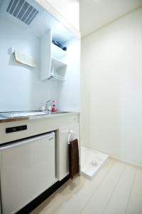 - une cuisine blanche avec un évier et un lave-vaisselle dans l'établissement R-Guest Residence 東京浅草 east2, à Tokyo