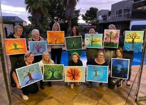 a group of people holding up their paintings of trees at Ultimate Barossa Retreats in Tanunda