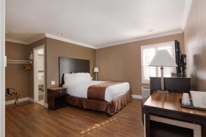 Pokój hotelowy z łóżkiem i biurkiem w obiekcie Americas Best Value Inn & Suites Anaheim w mieście Anaheim