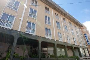 a large tan building with windows and balconies at Hotel Costa de Prata 2 & Spa in Figueira da Foz