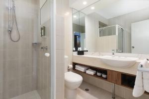 a bathroom with a sink and a toilet and a shower at Killara Hotel & Suites in Killara