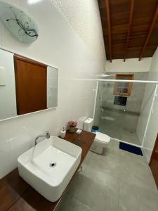 Baño blanco con lavabo y aseo en Chácara Klein, en Itupeva