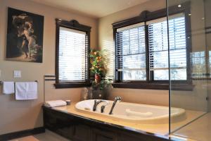 baño grande con bañera y ventana en Westmount River Inn en Calgary