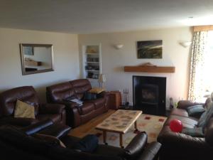 a living room with leather furniture and a fireplace at Langside in Stirling