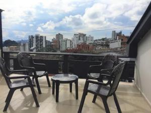 a balcony with chairs and tables and a view of a city at Casa Azul in Manizales