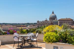 a table and chairs on a balcony with a view of a city at Atlante Star Hotel in Rome