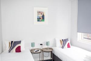 two beds in a room with white walls at Five Island Hotel in Cringila