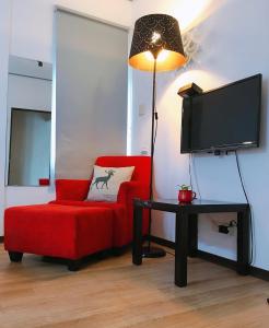 a living room with a red chair and a flat screen tv at in墾丁 in Kenting