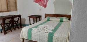 a bed in a room with two chairs and a table at Centro Ecoturistico Ya´ajche in Lacanjá