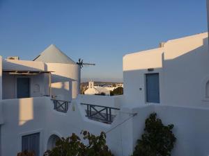 uma vista para os telhados de edifícios brancos em Teoria Paros - Matsas Windmill em Naousa