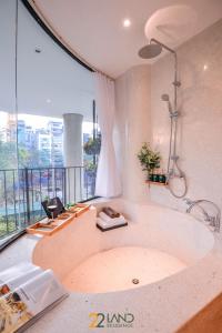 a large bath tub in a room with a window at 22Land Hotel & Residence in Hanoi