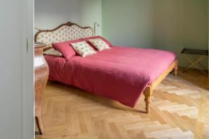 a bedroom with a large bed with a pink blanket at Ca' Maggiolina B&B in Milan