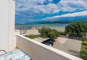 einen Balkon mit Blick auf einen Wasserkörper in der Unterkunft Apartments Blue Skies - 30 m from the sea in Ljubač