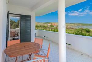 einen Tisch und Stühle auf einem Balkon mit Meerblick in der Unterkunft Apartments Blue Skies - 30 m from the sea in Ljubač