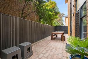 a wooden bench sitting next to a brick wall at Bayswaterfront Apartments in Adelaide