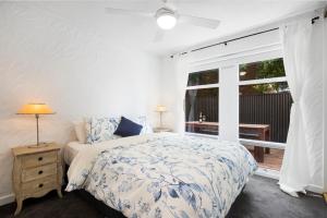 een slaapkamer met een bed en een groot raam bij Bayswaterfront Apartments in Adelaide