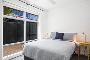 a bedroom with a bed and a large window at Bayswaterfront Apartments in Adelaide