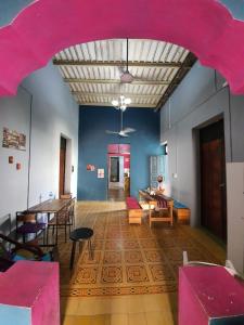 una grande stanza con tavoli e sedie e un soffitto rosa di Hostal Xiinbal a Mérida