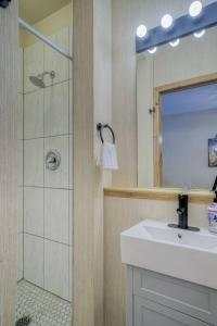 a bathroom with a sink and a shower and a mirror at 5 Mins to Banff - Cozy Townhome 2BR&2BATH - Banff Pass Included in Canmore