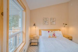 1 dormitorio con cama y ventana grande en 5 Mins to Banff - Cozy Townhome 2BR&2BATH - Banff Pass Included en Canmore