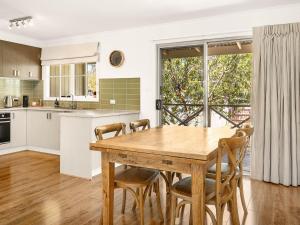 a kitchen with a wooden table and chairs at Clifden Cottage in Cowes