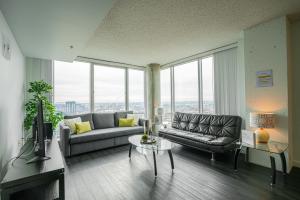 a living room with a couch and a tv and windows at 2BR Furnished Apartment in Baltimore Downtown apts in Baltimore
