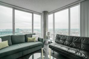 uma sala de estar com um sofá e janelas grandes em 2BR Furnished Apartment in Baltimore Downtown apts em Baltimore